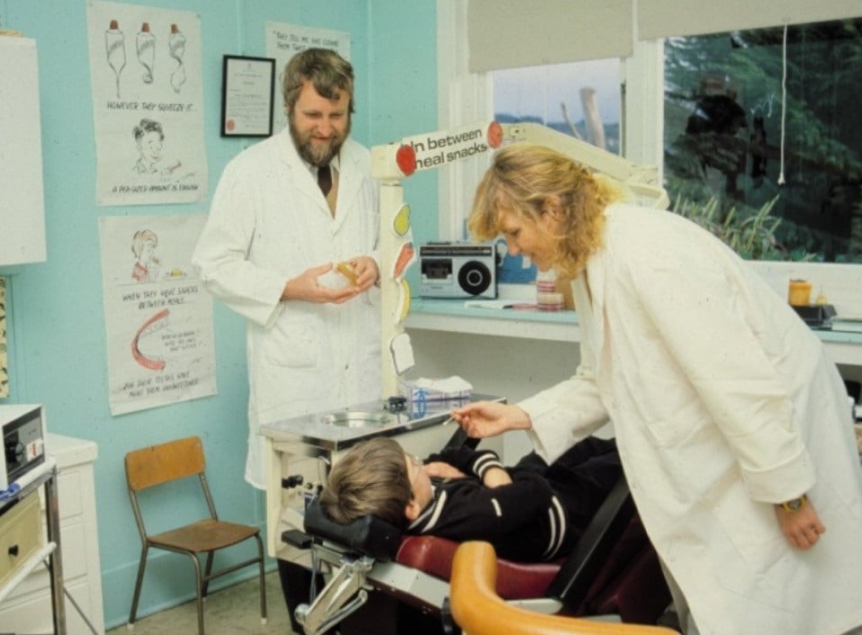 Archive image of Professor John Tagg and a colleague collecting oral samples from a child
