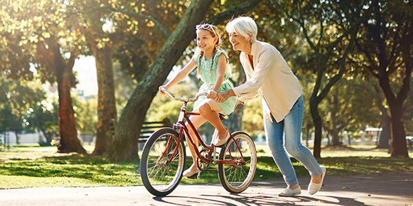 Woman teaching girl to ride bike