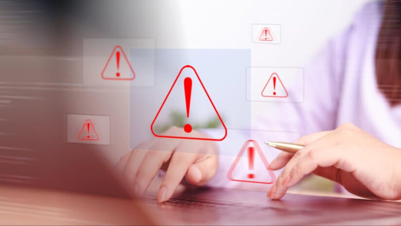Person at computer with warning symbols