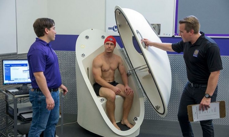 Ryan Durk (left) and Jimmy Bagley (right) pop Donny Frances Gregg into the BOD POD to evaluate his body composition. ©San Francisco State University